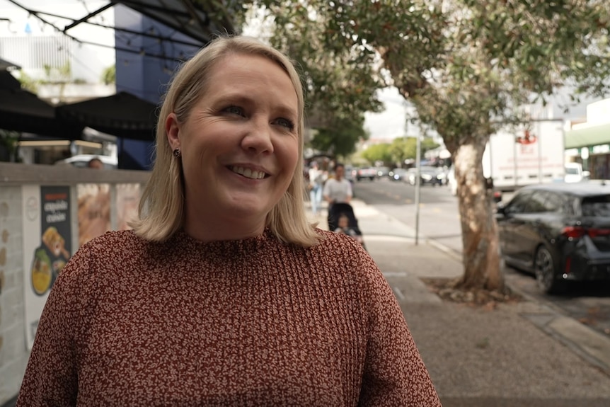 Kasey Drake speaking on a street.