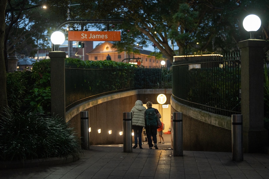 Commuters walk into the entrance of St James train station.