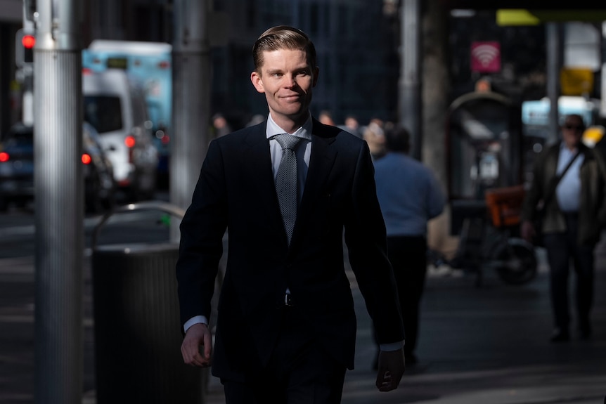 Man in suit smiling walking in the street