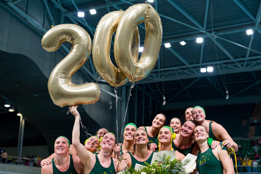 The Stingers stand under baloons with 200