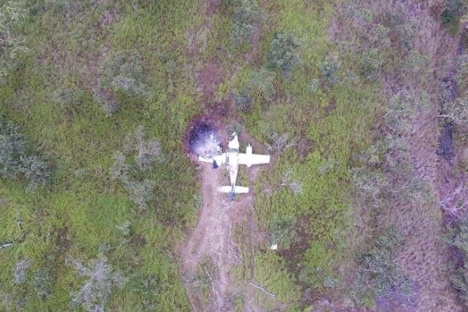An aerial shot showing a crashed plane at the end of the makeshift runway in PNG.