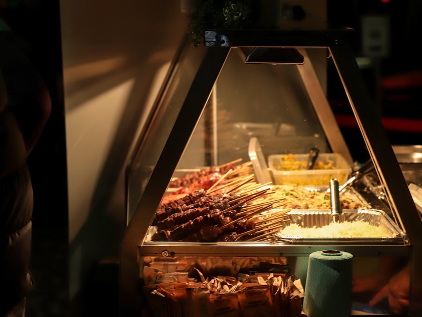 A bain maire with rows of different meat skewers under a warming light