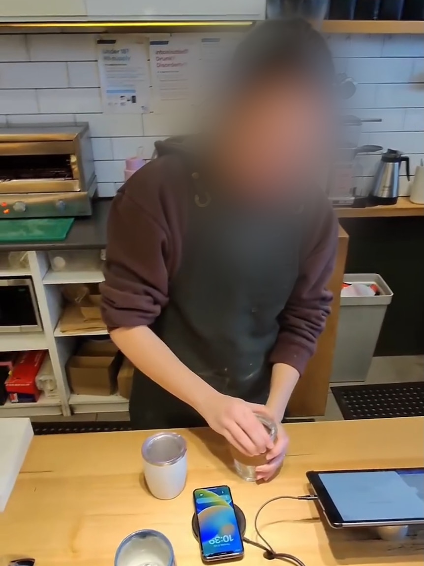 A cafe worker makes a coffee.