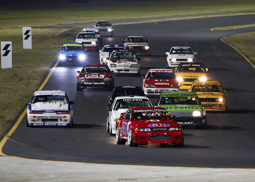 Yellow Benson & Hedges BMW E30 M3 leading a group of Heritage Touring Cars on track.