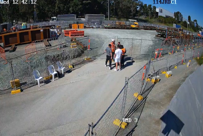 Men approaching construction site worker