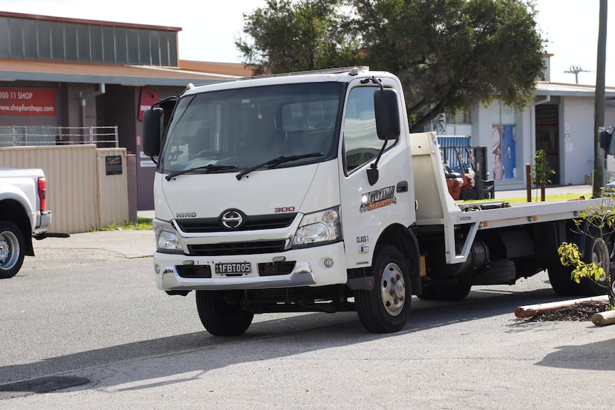 A towing truck is seen on a street.