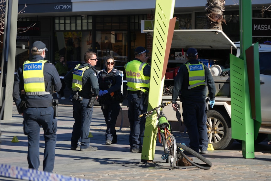 Police officer near a white ute and a mangled push bike