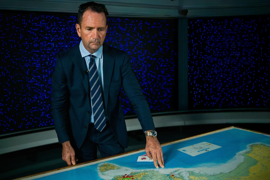 A man in a studio with a map.