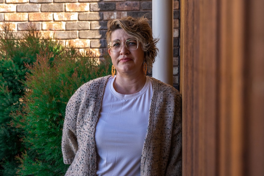 A woman leaning against a wall.
