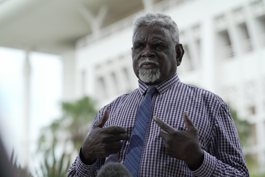 A man in a checked shirt and tie