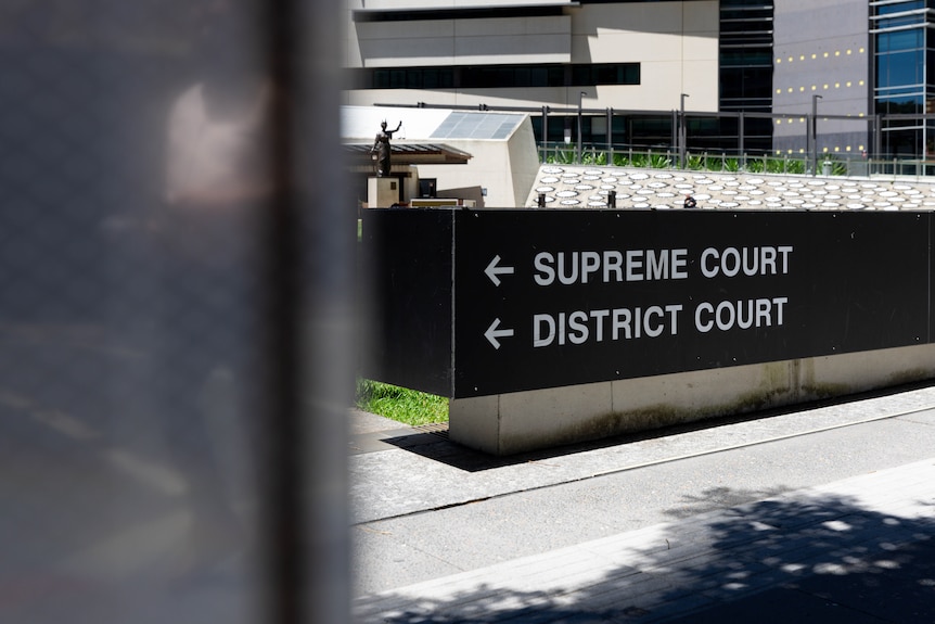 A black sign showing Brisbane's Supreme and District Court.