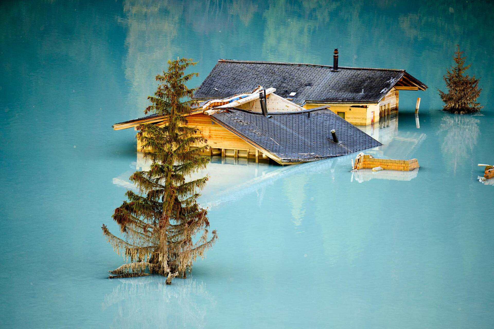 Série «Blatten 2030» – Des maisons détruites et inondées dans le village de Blatten lors de la cérémonie de pose de la première pierre du projet de reconstruction, le 19 septembre 2025. — © Laurent Gillieron /Keystone