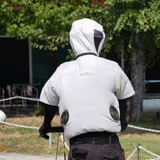Une personne porte une combinaison de climatisation pour travailler dehors lorsqu'il fait chaud.