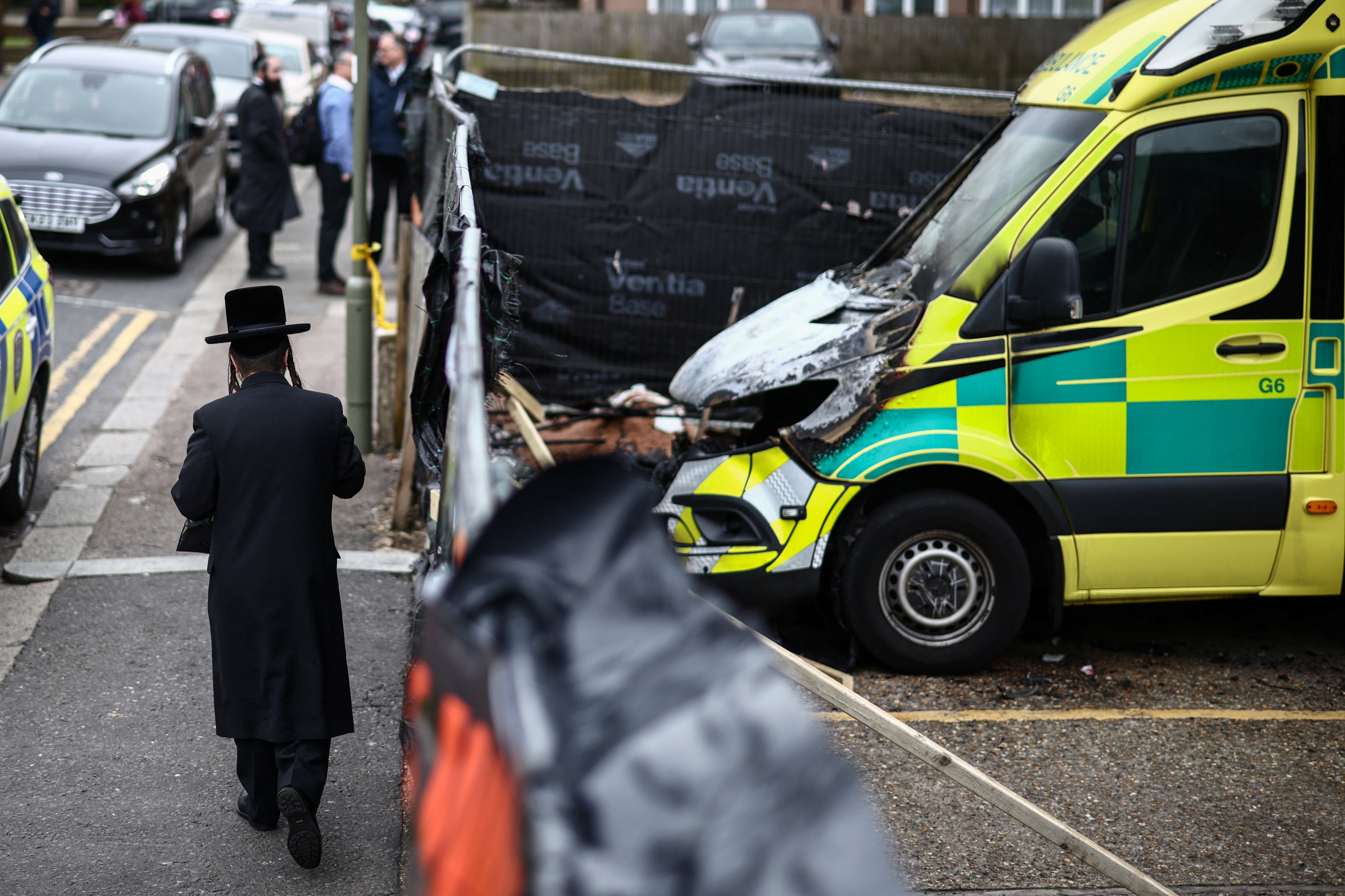 A member (L) of the Jewish community walks past the scene of an antisemitic arson attack in the Golders Green neighbourhood of north London, on March 24, 2026