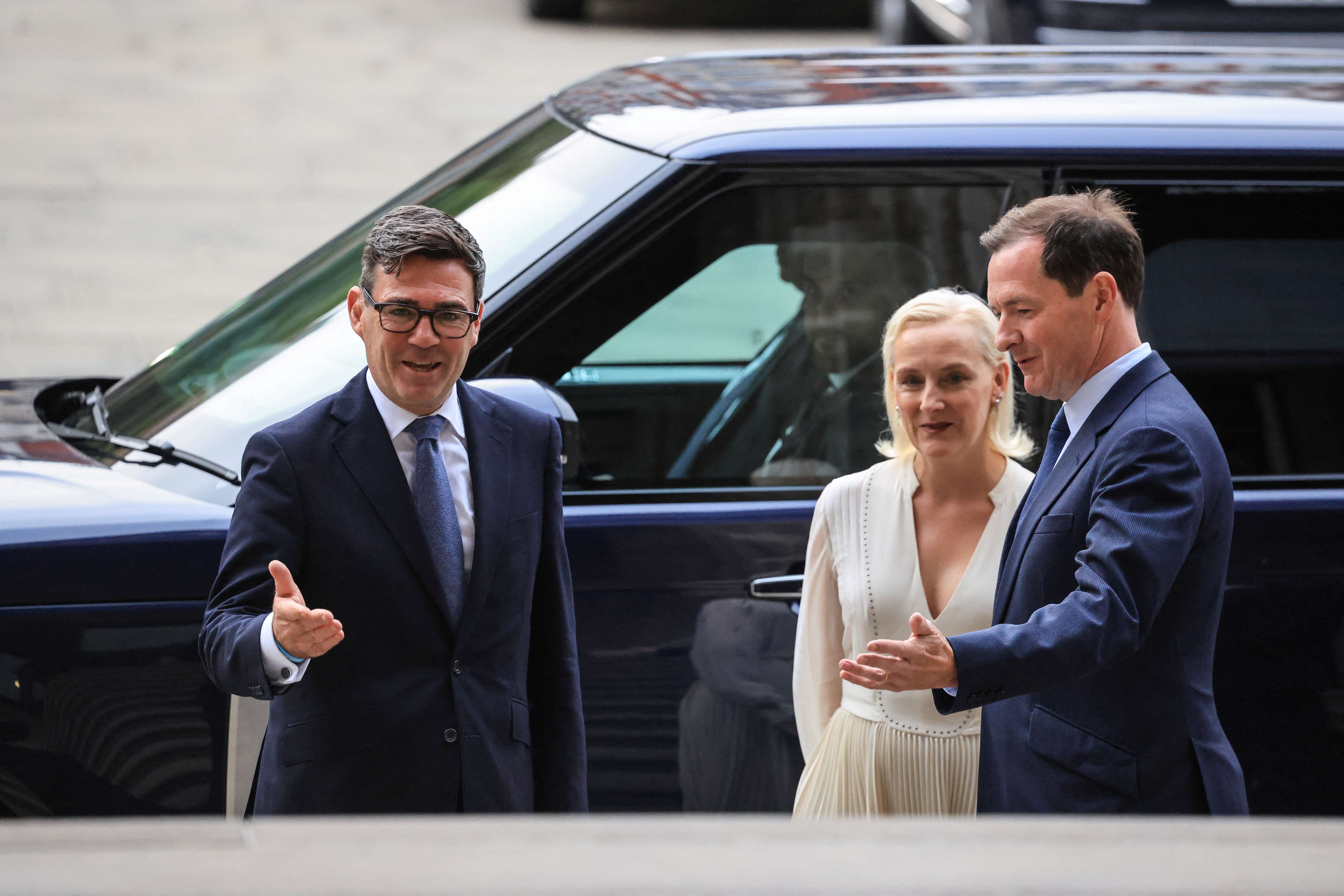 Andy Burnham, left, and his wife Marie-France van Heel, centre, are greeted by British Museum chair George Osborne, right