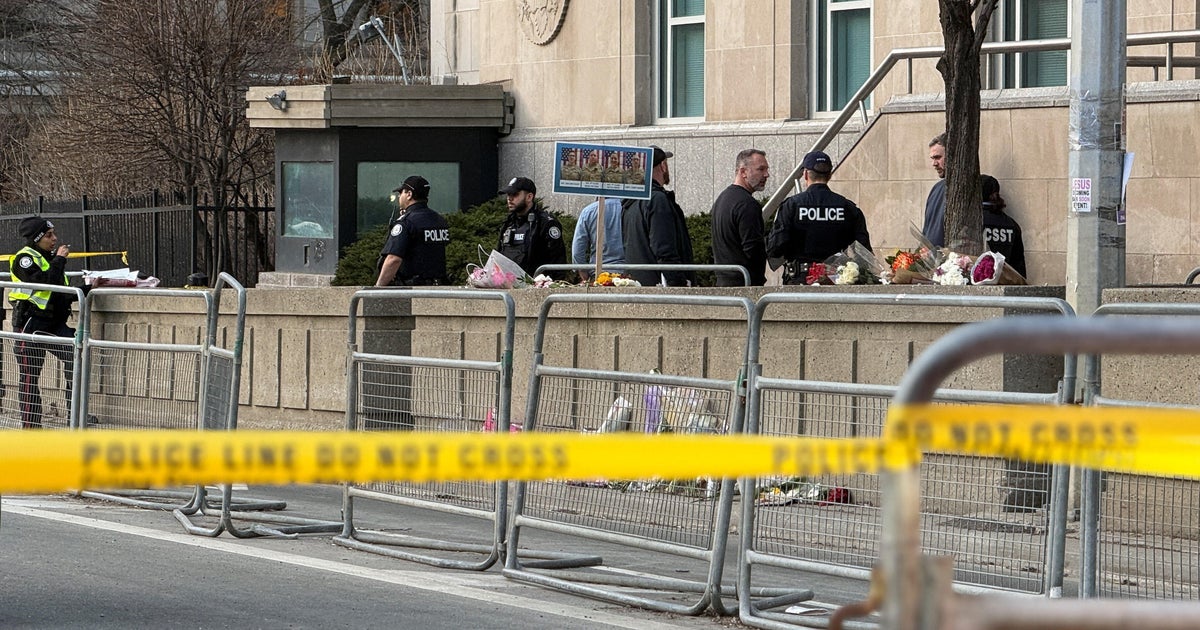 Officer killed, "armed and dangerous" suspect on run in Canada linked to shooting at U.S. consulate