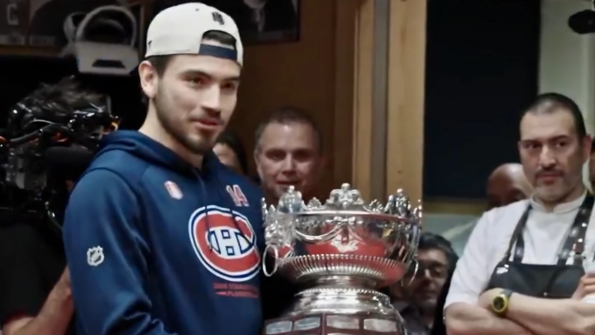 Photo of Nick Suzuki holding the Selke Trophy.