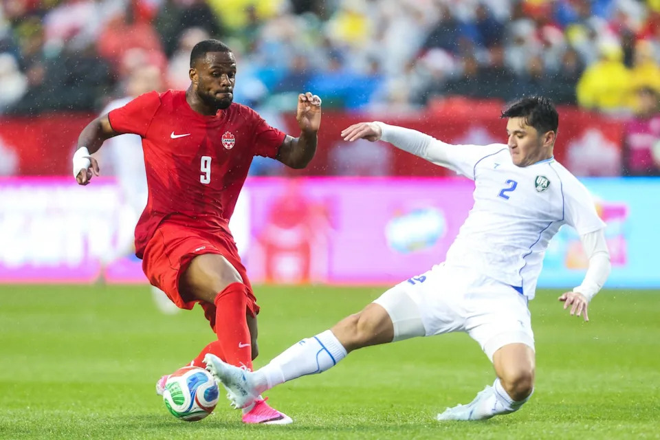 Canada's Cyle Larin (9) has the ball kicked away by Uzbekistan's Abdukodir Khusanov (2) during first half World Cup Friendly soccer action in Edmonton on Monday, June 1, 2026. THE CANADIAN PRESS/Codie McLachlan