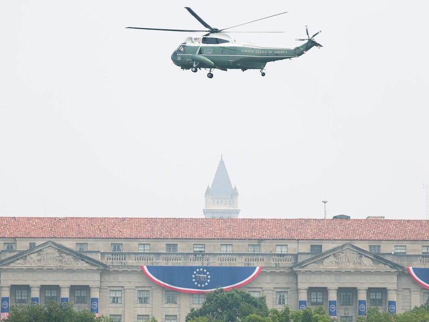 A helicopter rises up in smoky air.