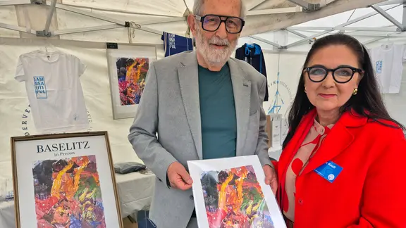 Günter Kern, Bruder von Georg Baselitz, erhält von Susan Knoll einen handsignierten Kunstdruck des Gemäldes. Kern hatte seit 1961 keinen Kontakt mehr zu seinem Bruder - und bedauert, dass er sich nicht verabschieden konnte. | NDR, Foto: Janet Lindemann Susan Knoll überreicht Günter Kern einen Kunstdruck von "Mein Vater sieht einen Engel".