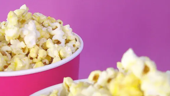 Zwei Eimer Popcorn vor pinkem Hintergrund. | tomhope / photocase.de, tomhope Zwei Eimer Popcorn vor pinkem Hintergrund.