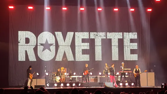 Die achtköpfige Band überzeugte in der Kieler Ostseehalle mit den alten Hits. | NDR, Linda Ebener Eine Bühne mit einer achtköpfigen Band: im Hintergrund der Schriftzug "Roxette".