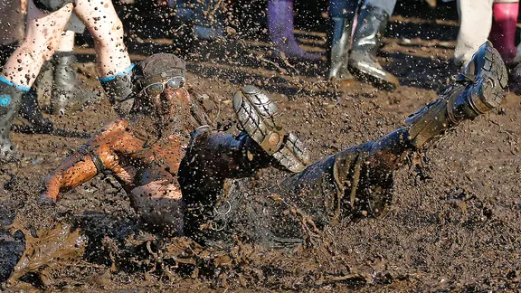 Festivalbesucher feiern beim Wacken Open-Air Festival (WOA) am 03.08.2013 im schleswig-holsteinischen Wacken auf der Festivalwiese im Schlamm. | picture alliance / dpa , Axel Heimken Festivalbesucher feiern beim Wacken Open-Air Festival (WOA) am 03.08.2013 im schleswig-holsteinischen Wacken auf der Festivalwiese im Schlamm.
