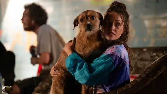 Justine (Eloïse Rey) ist die Schwester eines der vermissten Kinder. | ARD Degeto Film/France Télévisions/Quad Drama/Fabien Malot Ein Mädchen im Vordergrund mit einem Hund auf dem Arm