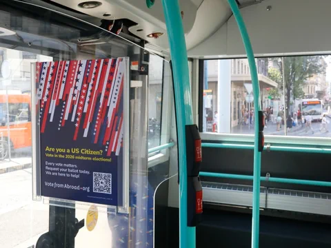 Innenraum eines Busses mit Plakat und Blick nach draussen.