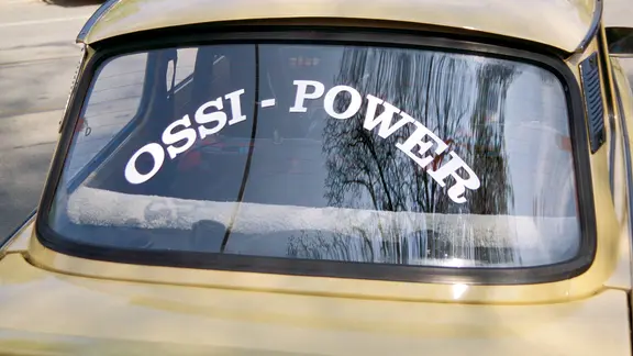 Schriftzug Ossi-Power auf dem rückfenster eines Trabbi | IMAGO / Steinach Schriftzug Ossi-Power auf dem rückfenster eines Trabbi