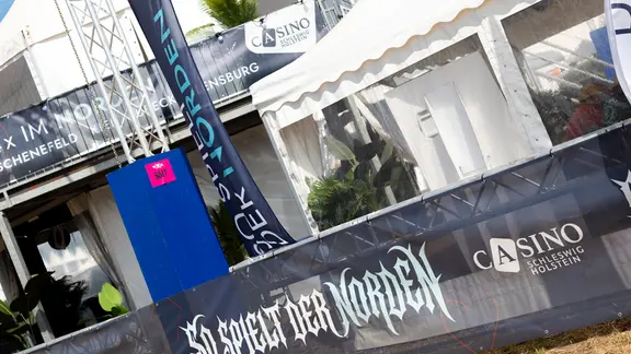 Zwischen Bier-, Essens- und Merch-Zelten wirbt das Casino Schleswig-Holstein für Glücksspiel. | Alexander Mühlhausen Casino-Werbung auf dem Wacken Open Air
