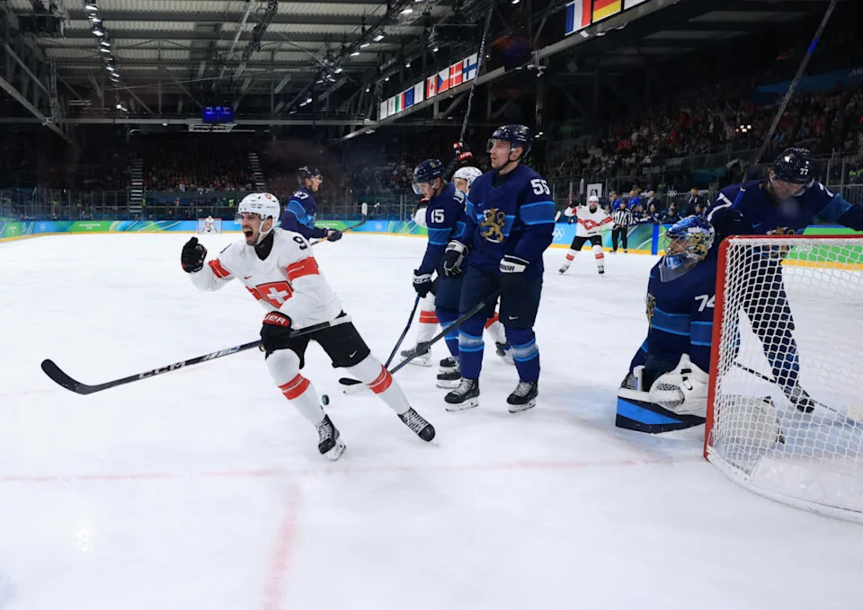 Feb 18, 2026; Milan, Italy; Damien Riat of Switzerland celebrates scoring their first goal as Rasmus Ristolainen of Finland and Juuse Saros of Finland look on in a men’s ice hockey quarterfinal during the Milano Cortina 2026 Olympic Winter Games at Milano Rho Ice Hockey Arena. Mandatory Credit: Katie Stratman-Imagn Images