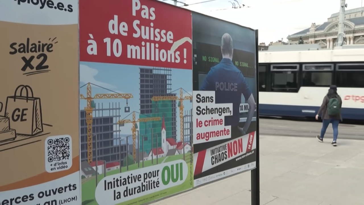 Swiss referendum posters about a 10 million population cap stand beside a tram stop