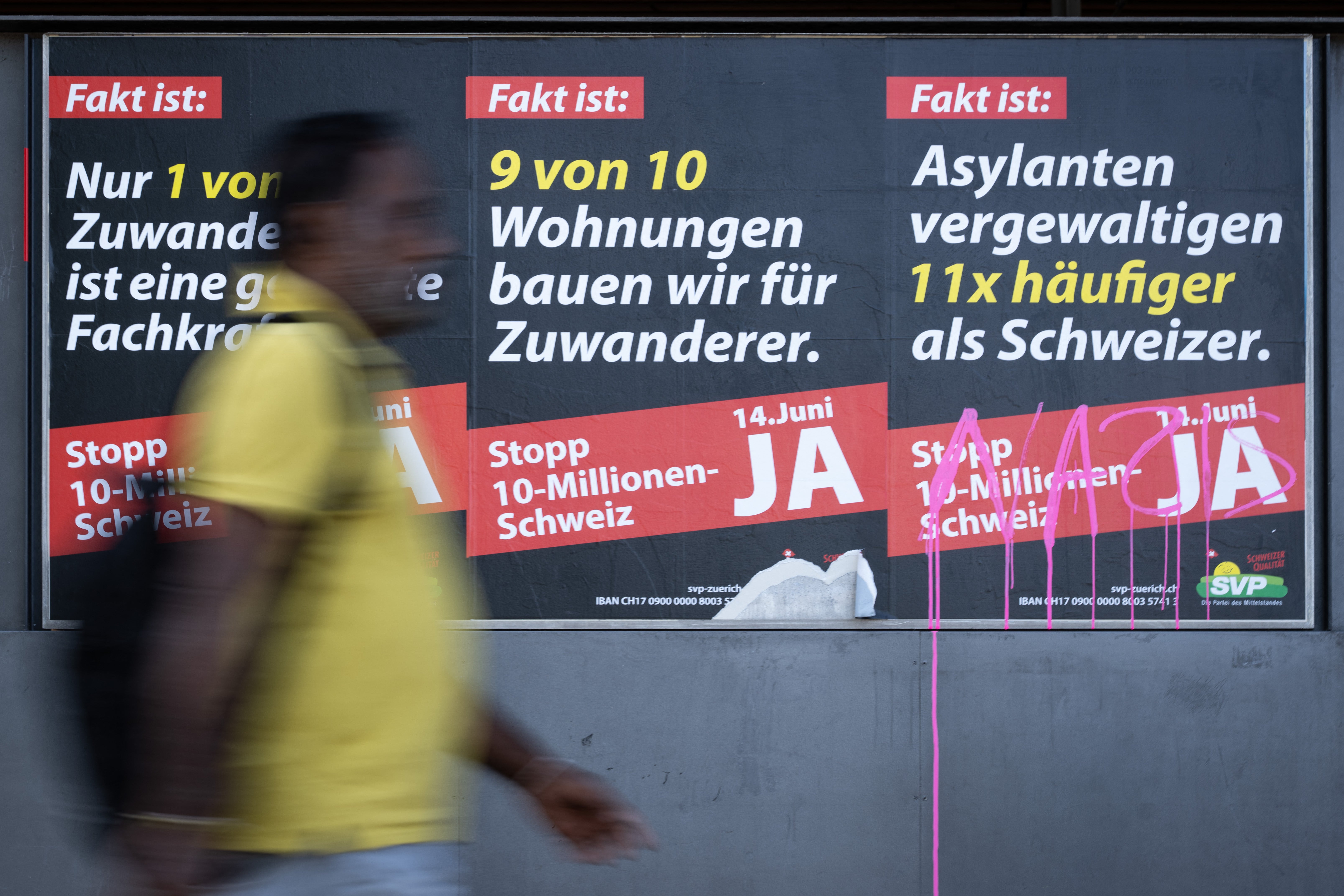 A man passes by posters campaigning for the 