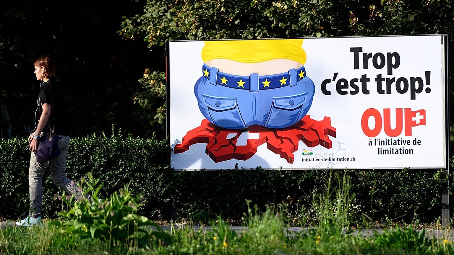 A Swiss People's Party campaign poster reading Enough is enough on a street in Lausanne