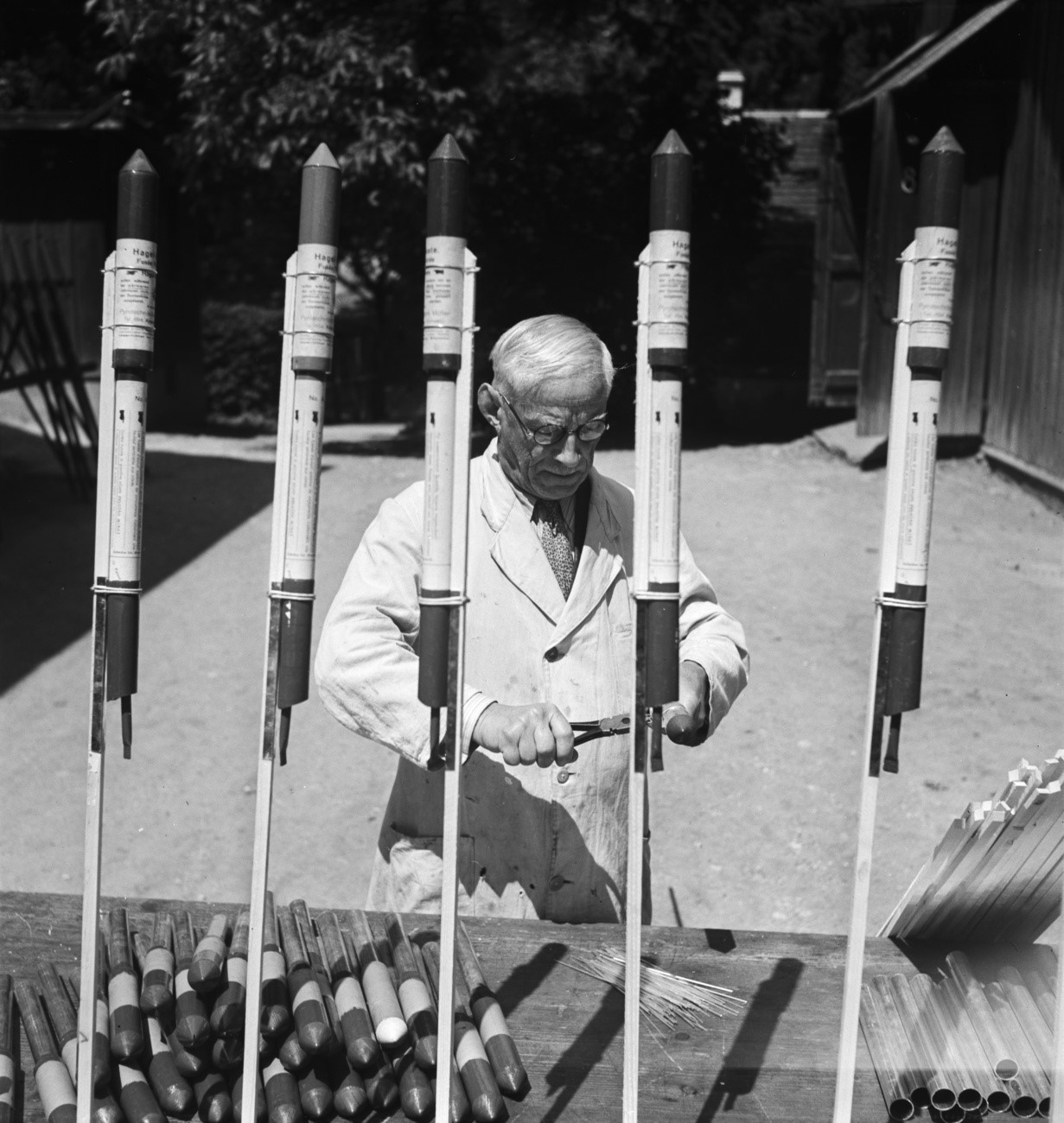 A man is preparing anti-hail rockets in a black-and-white photograph
