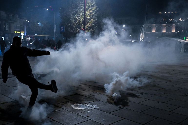 A protester kicks a tear gas canister fired by riot police outside Kosovo’s Parliament on October 5