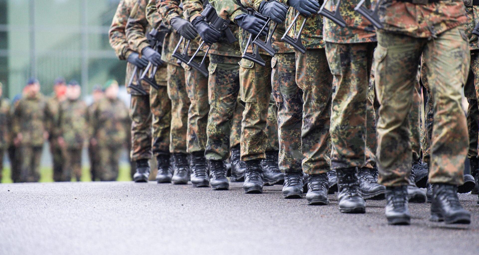 Soldaten marschieren mit Gewehr in Reih und Glied
