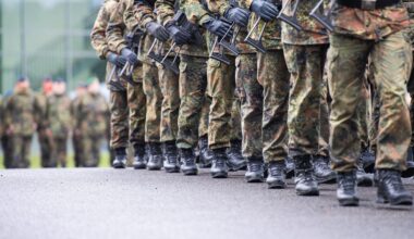 Soldaten marschieren mit Gewehr in Reih und Glied