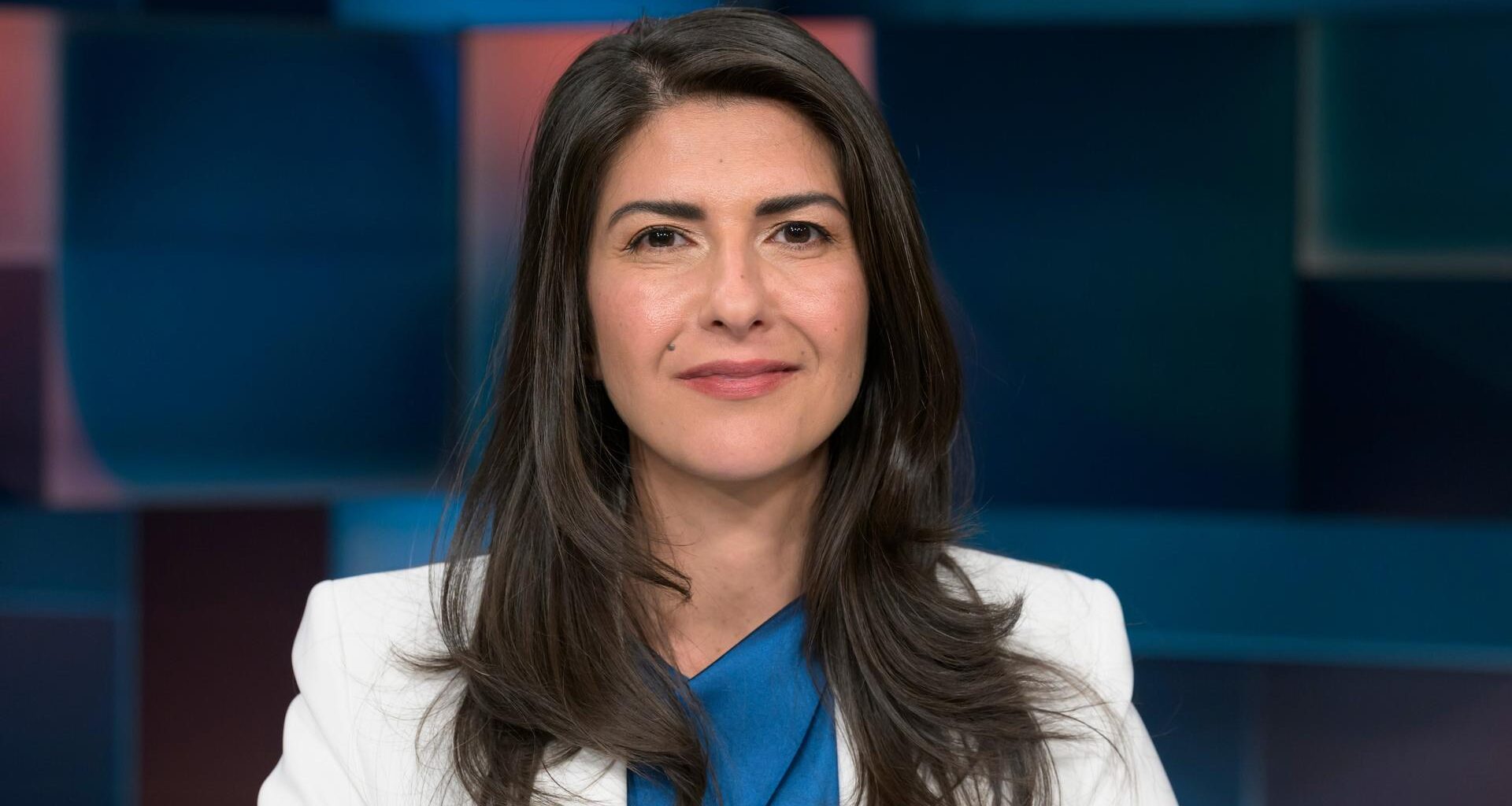CDU-Politikerin Serap Güler, mit weißem Jackett zur blauen Bluse, mit langen dunklen Haaren.