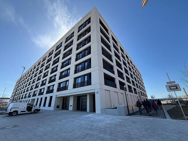 So sieht das erste fertige Wohnhaus von außen aus. Ein privates Unternehmen hat es errichtet. Dieses wollte eigentlich noch viel mehr Wohnungen bauen. Dann sind die Baukosten explodiert.