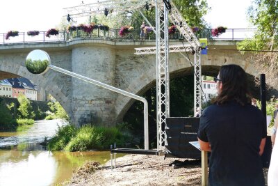 „Fließgleichgewicht“ in Zschopau: Der 4,50 Meter hohe Spiegel des Künstlers Michael Sailstorfer am Zschopau-Ufer greift den physikalischen Begriff des dynamischen Fließgleichgewichts auf, erinnert aber auch an die Seitenspiegel der berühmten Motorräder aus dem inzwischen stillgelegten, einst größten Motorradwerk der Welt in Zschopau.