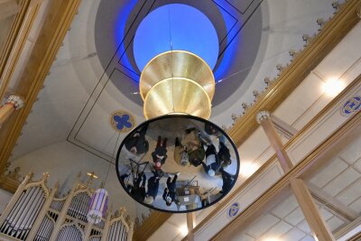 „The Universe in a Pearl“ in Lößnitz: Die senkrecht angeordnete mehrteilige Installation von Rebecca Horn (1944 – 2024) eröffnet mittels mehrerer Spiegel, blauen Lichtes und goldener Trichter Reflexionsräume, die sich scheinbar ins Unendliche fortsetzen.