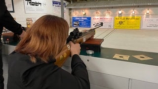Eine junge Frau zielt mit einem Luftgewehr auf eine Zielscheibe beim Ostereierschießen in Ramsen
