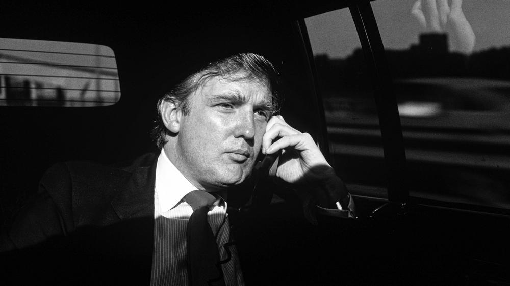 Donald Trump: Donald Trump im August 1987, wie er sich in einer Limousine durch New York City chauffieren lässt, und natürlich ist Trump am Telefon, bestimmt einen Deal abschließen. Wenige Monate später, im November 1987, ist das Buch "The Art of the Deal" in den USA erschienen.
