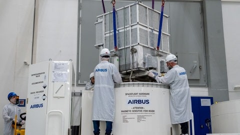 Ingenieure von Airbus verladen ACES in einem Frachtraum.