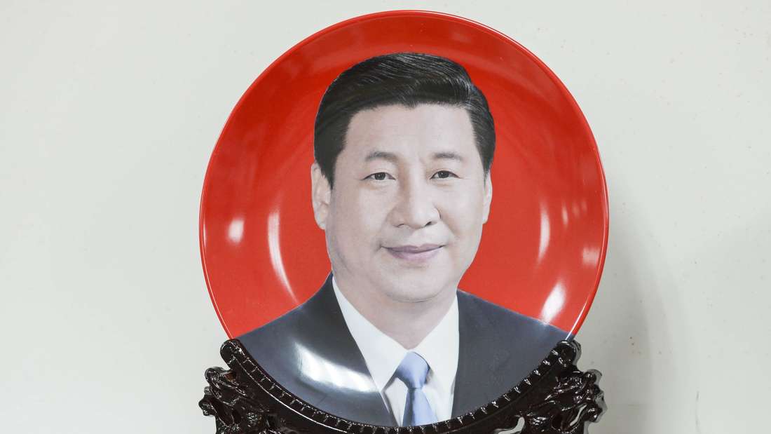 Xi Jinpings Konterfei lächelt von einem Teller mit rotem Hintergrund
