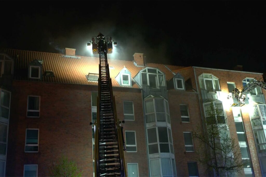 Feuerwehrleute auf zwei Drehleitern vor dem Brandhaus in Dortmund.