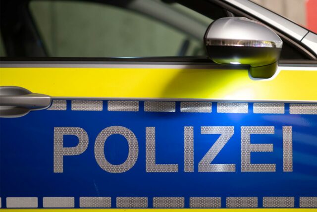 Das Wort Polizei ist auf der Tür eines Polizeiautos zu lesen.