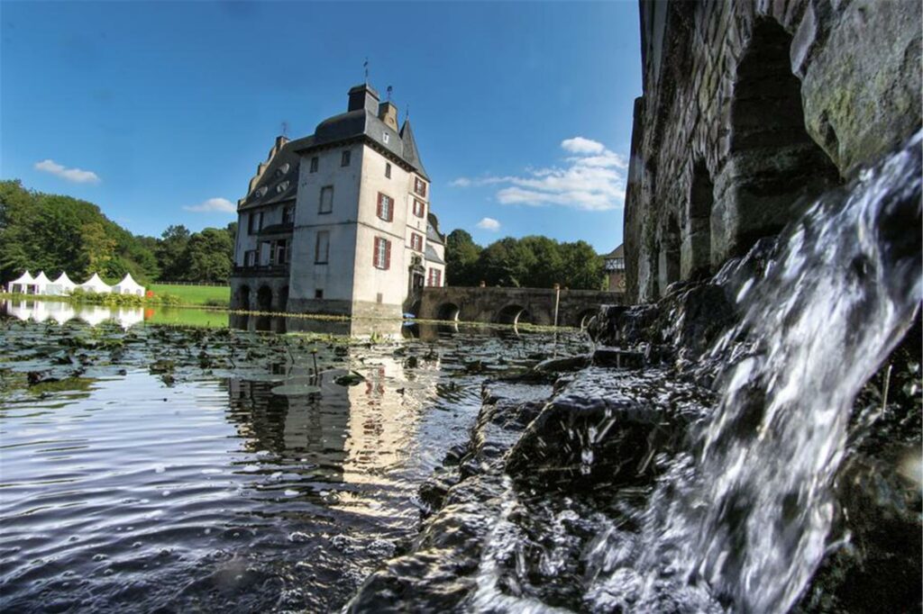 Wasser sprudelt in die Gräfte von Schloss Bodelschwingh. 